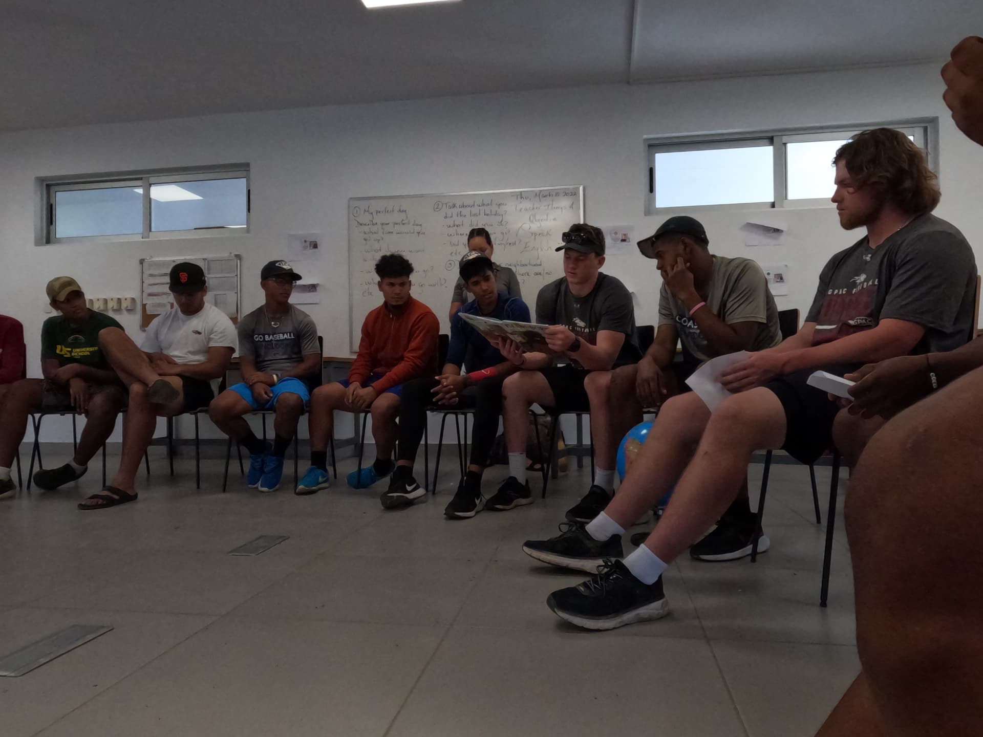Athletes and local youth sharing a reading and discussion time
